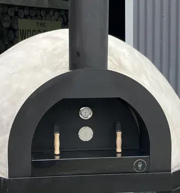 Black Wood-fired Pizza Oven With Arched Opening and Tall Chimney — Complete Heating In Huntingfield, TAS