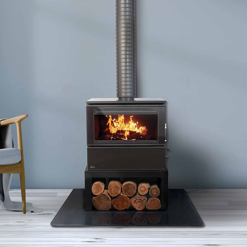 Black Wood Stove With a Burning Fire and Stacked Logs on a Black Mat — Complete Heating In Huntingfield, TAS