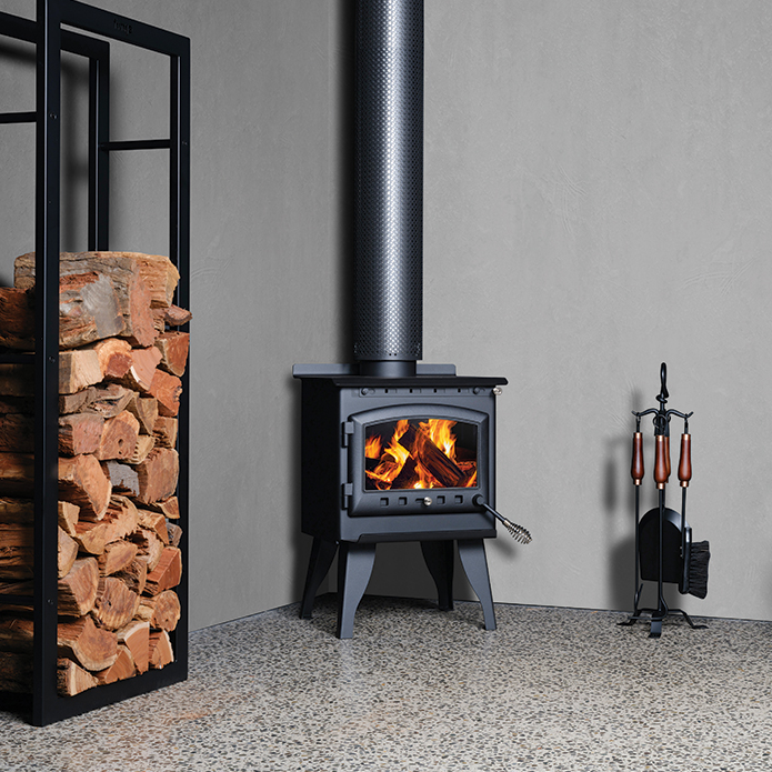 Modern Black Wood Stove With Lit Fire and Chimney Beside Stacked Firewood — Complete Heating In Huntingfield, TAS
