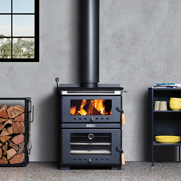 Wood Stove With Fire in a Grey Room, Flanked by Stacked Firewood — Complete Heating In Huntingfield, TAS