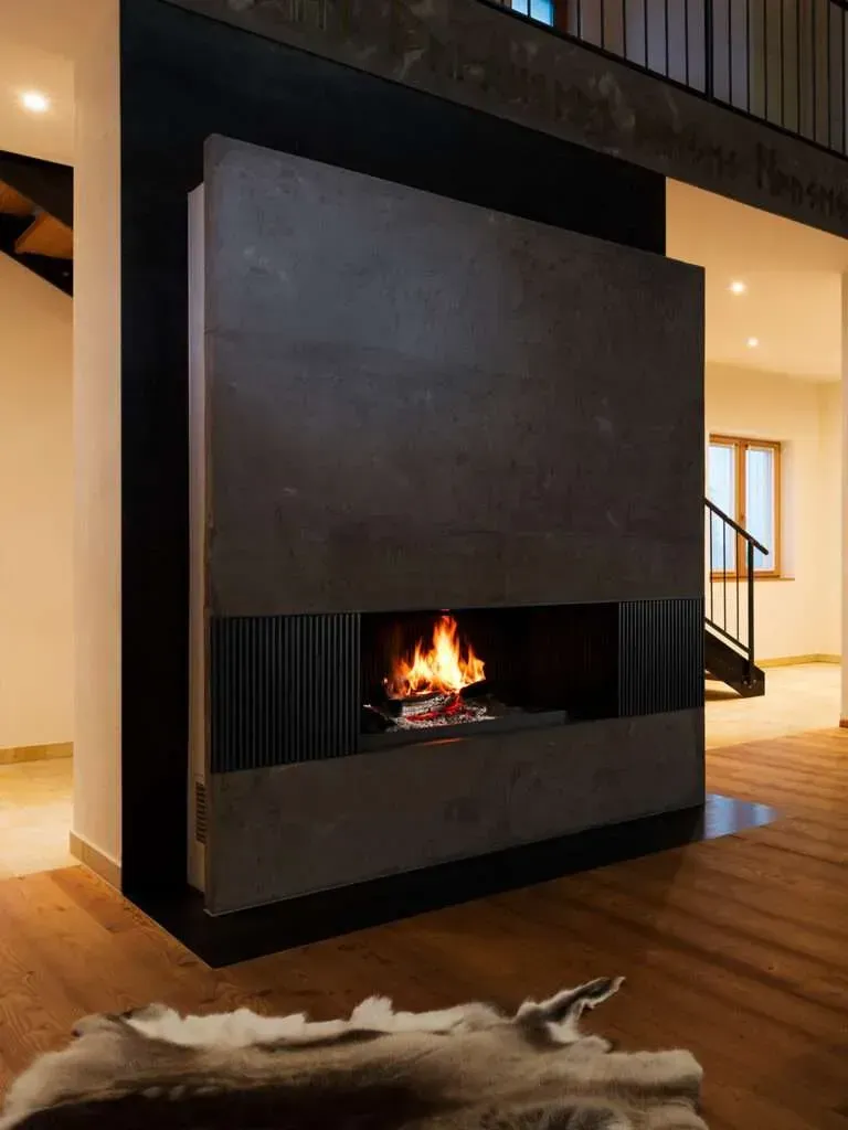 Living Room With a Large Black Fireplace and a Small Flame — Complete Heating In Huntingfield, TAS