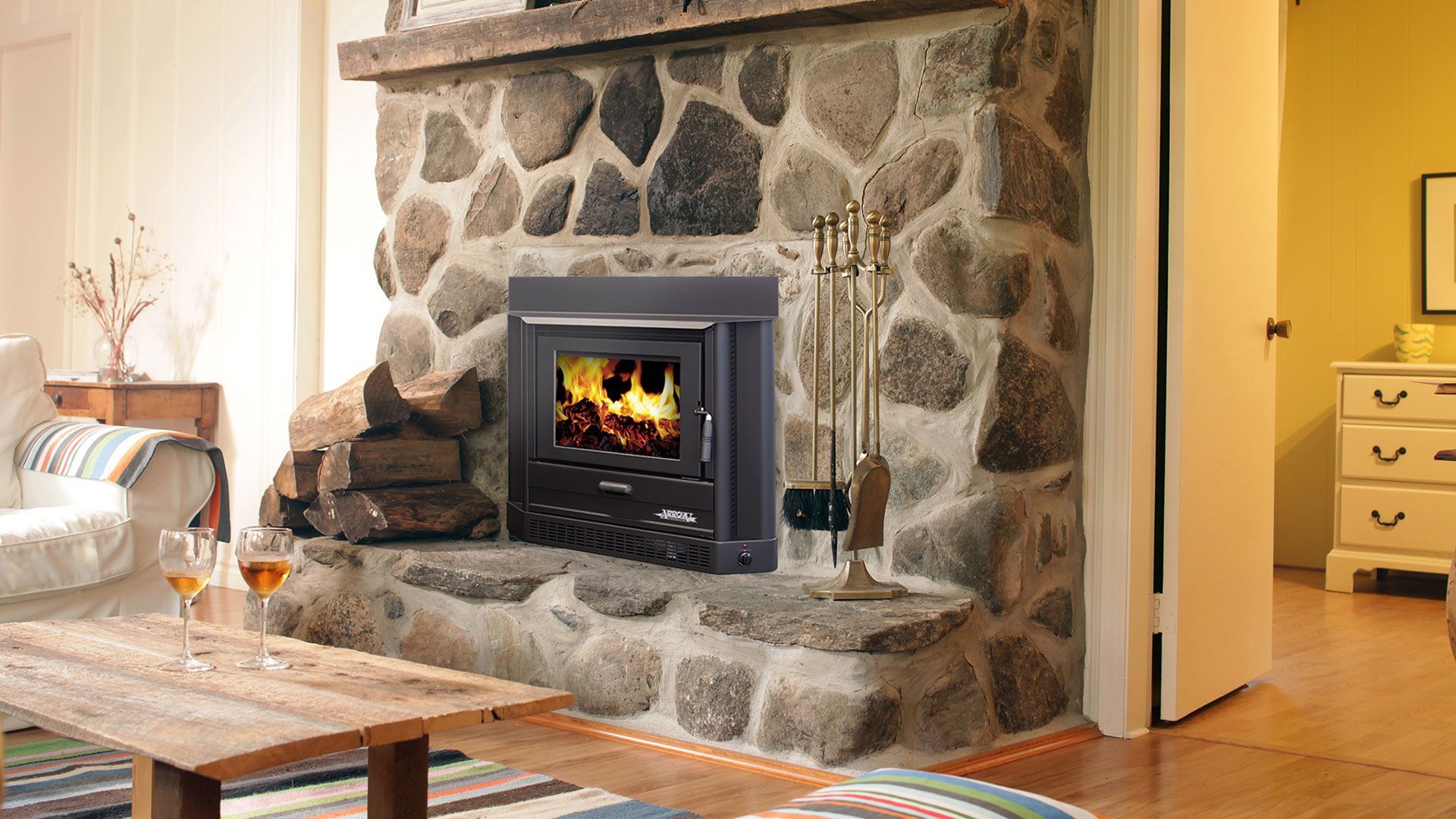 Cozy Living Room With Stone Fireplace and Lit Fire — Complete Heating In Huntingfield, TAS