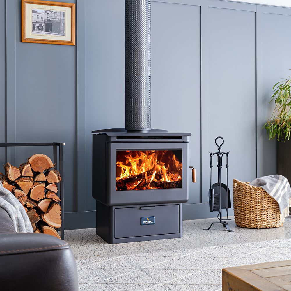 Black Wood Stove With a Fire Burning in a Modern Living Room — Complete Heating In Huntingfield, TAS