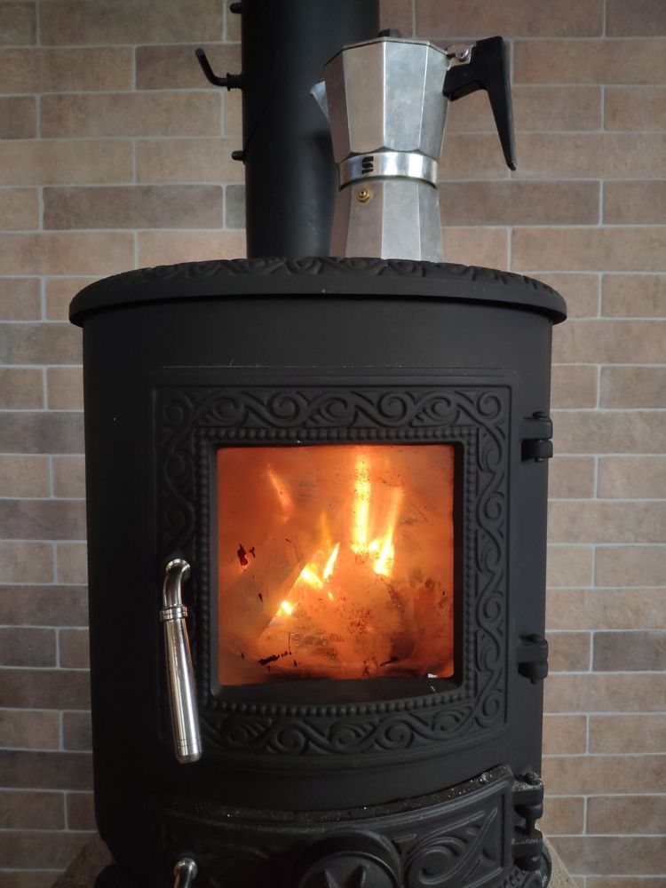 A Silver Moka Pot Sits on Top of a Black Wood-burning Stove — Complete Heating In Huntingfield, TAS