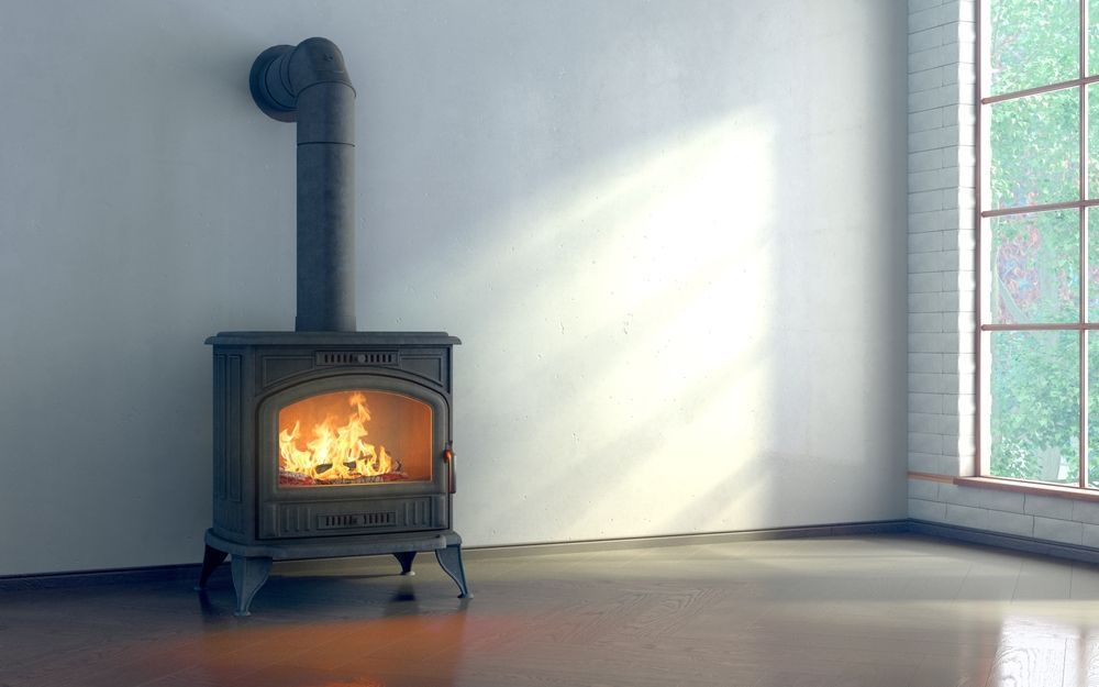 A Cast-iron Wood Stove With a Burning Fire — Complete Heating In Huntingfield, TAS