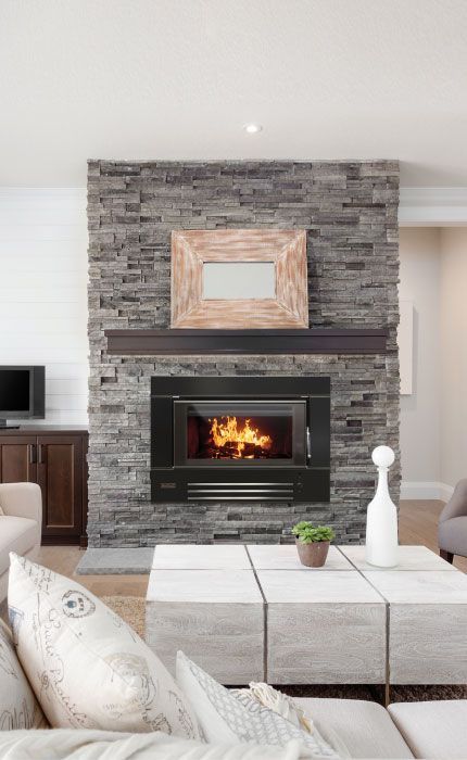 Living Room With Stone Fireplace, Lit Fire, and Light-colored Sofas — Complete Heating In Huntingfield, TAS
