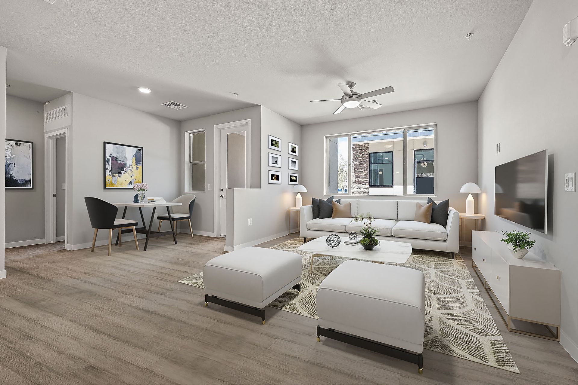 A living room with white furniture and a flat screen tv