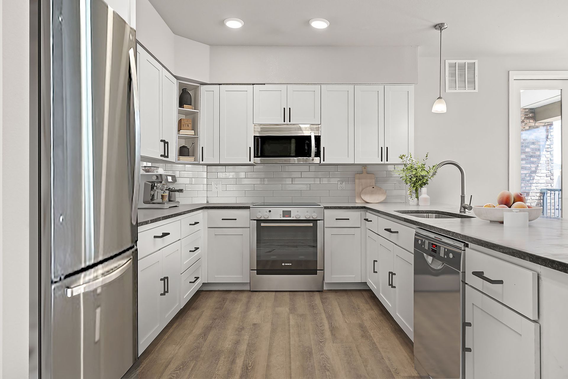 A kitchen with white cabinets and stainless steel appliances.