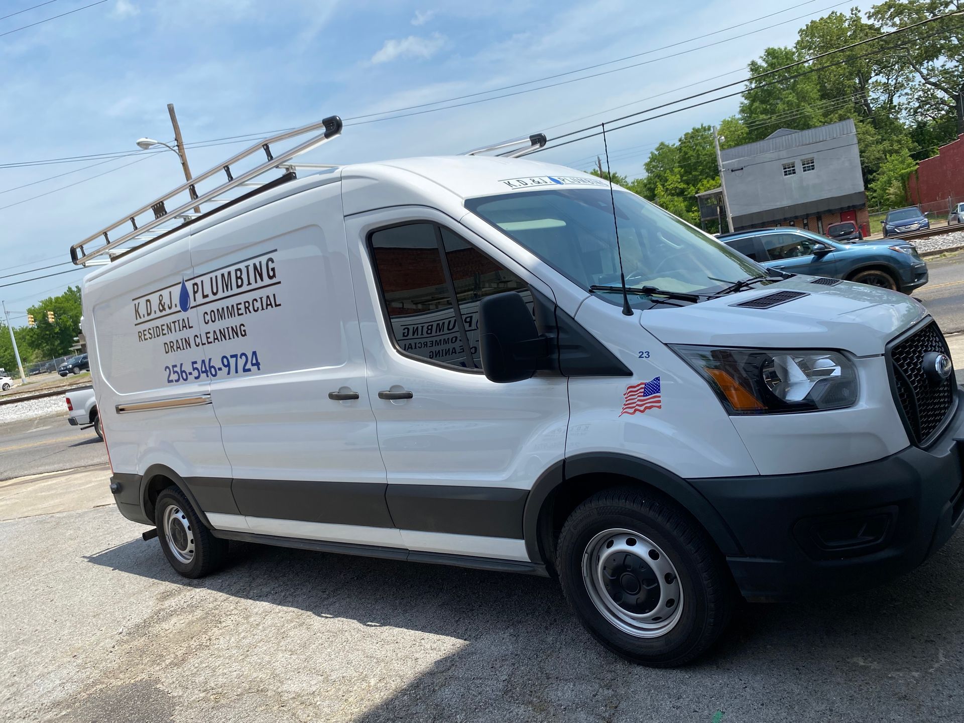 White cargo van with company lettering parked in a lot on a sunny day. White cargo van with company lettering parked in a lot on a sunny day.
