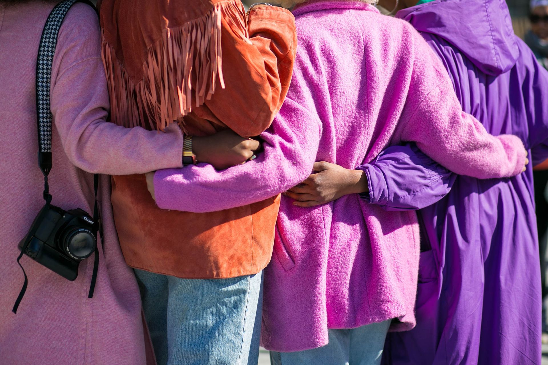 a group of people are hugging each other in a row .