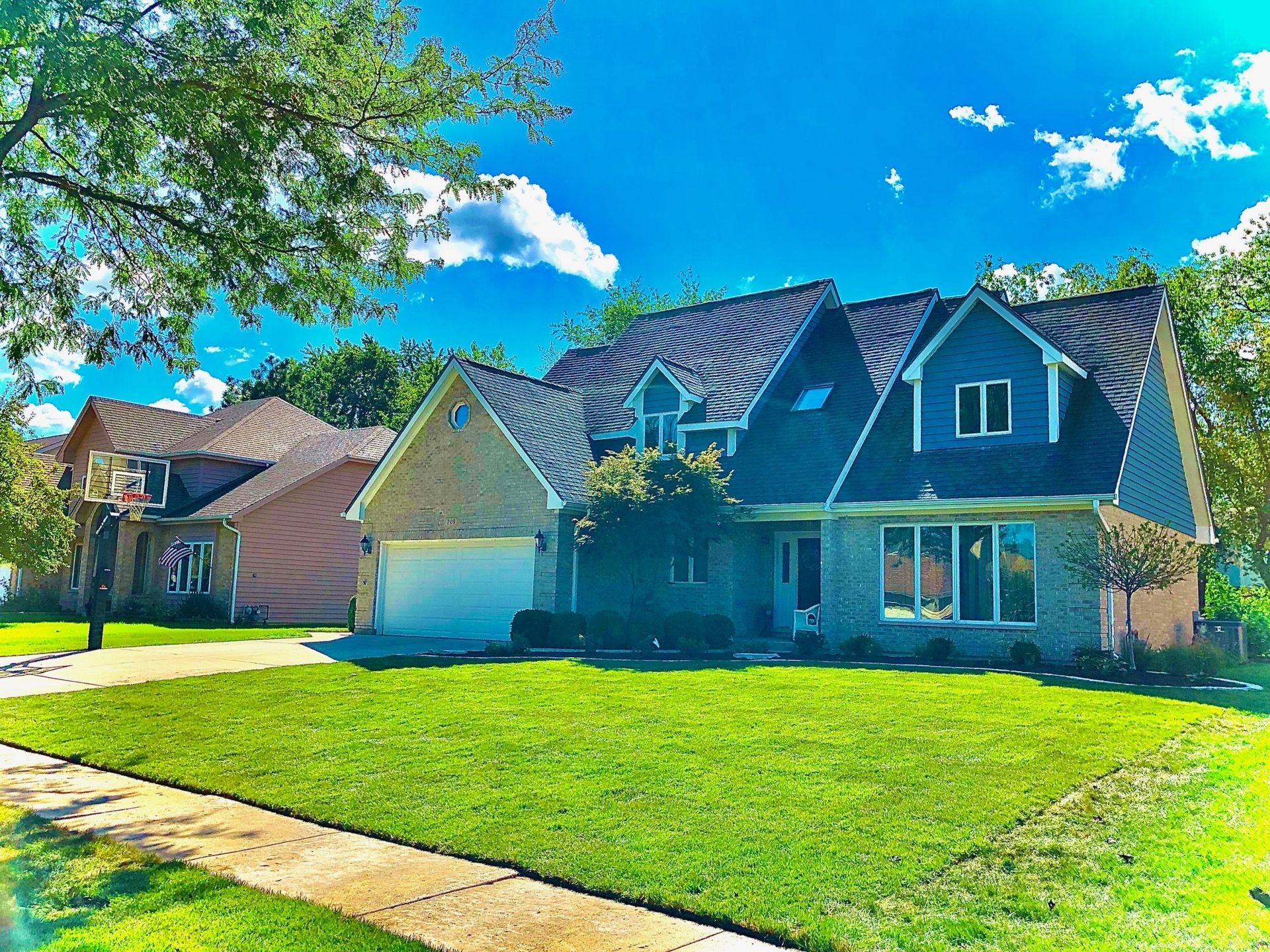 Houses with green lawns and blue sky.