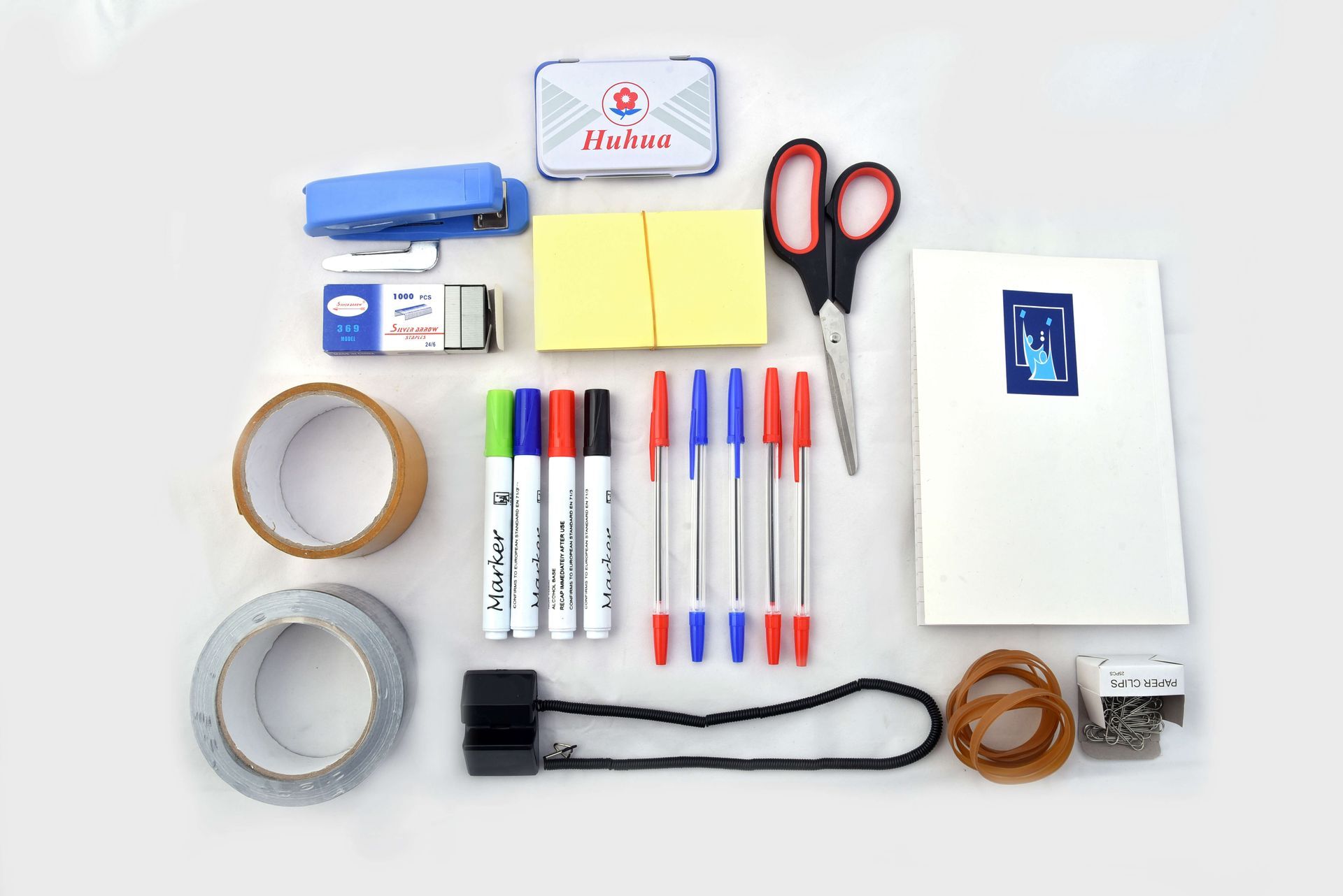 A variety of office supplies are laid out on a white surface