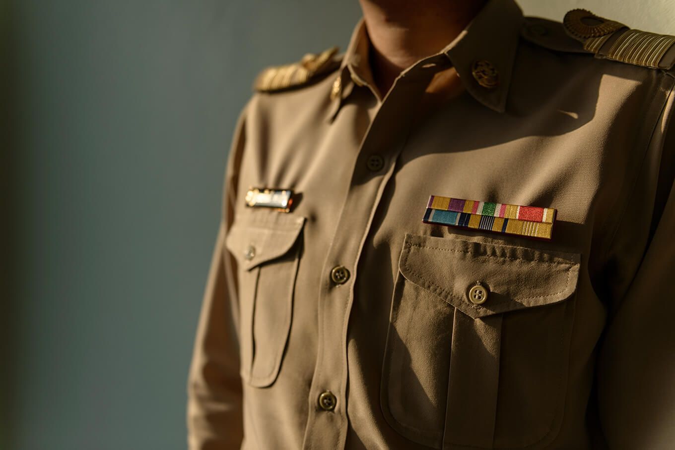 A man in a military uniform has several ribbons on his chest