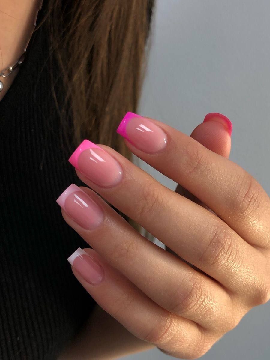 A close-up of a hand displaying a French manicure with square-shaped tips in varying shades of pink and white.