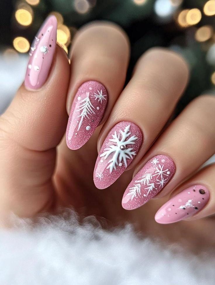 Hand with long, almond-shaped dusty pink nails decorated with white, hand-painted snowflakes and tiny evergreen trees.
