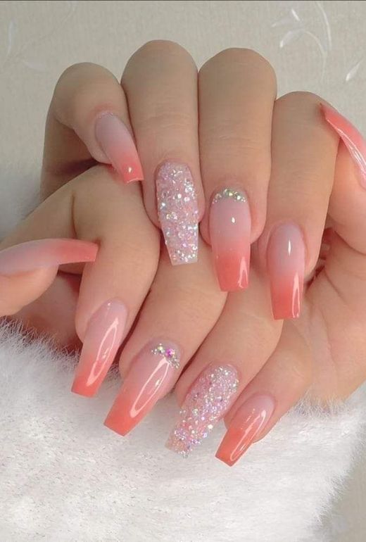 Coffin-shaped nails featuring a coral-pink ombre gradient, accented with silver glitter, rhinestones, and full-glitter nails.