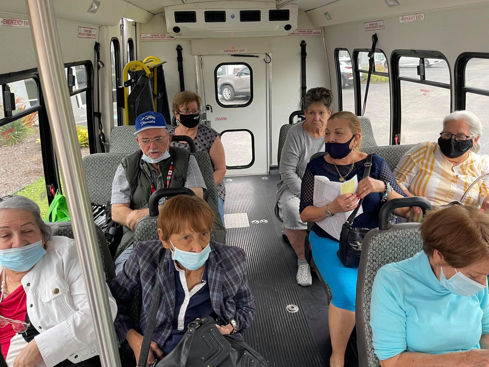 People wearing masks seated inside a bus, likely for transportation.