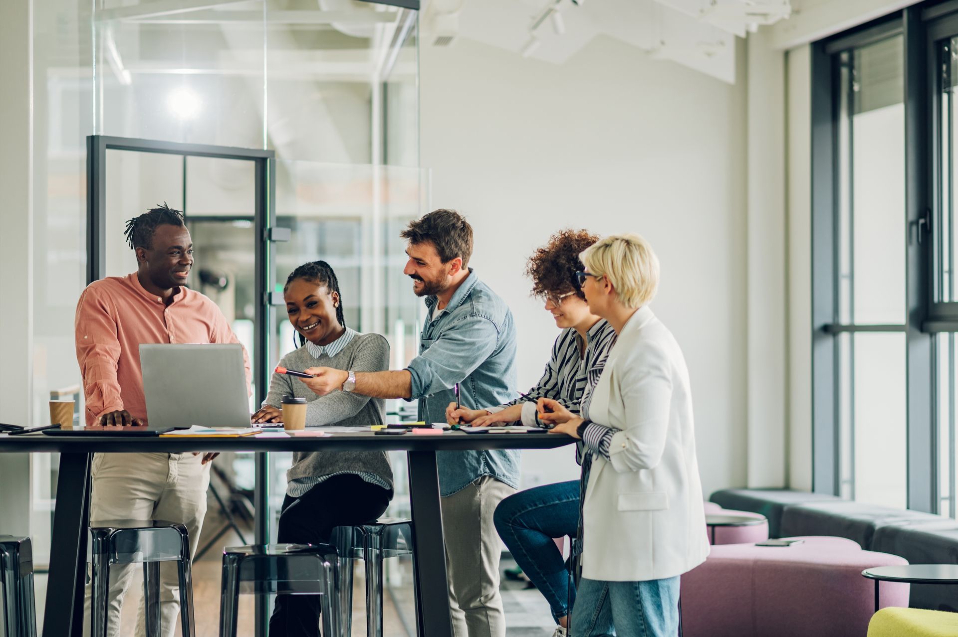 Five diverse colleagues collaborate around a table