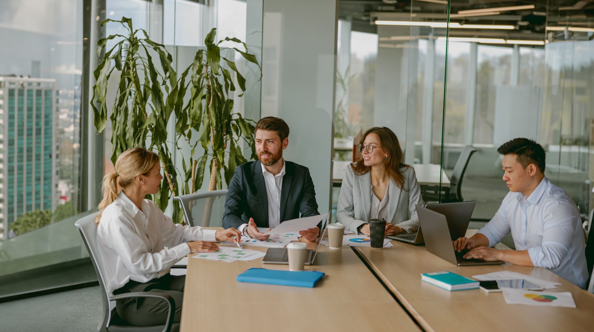 Four businesspeople in a modern office meeting