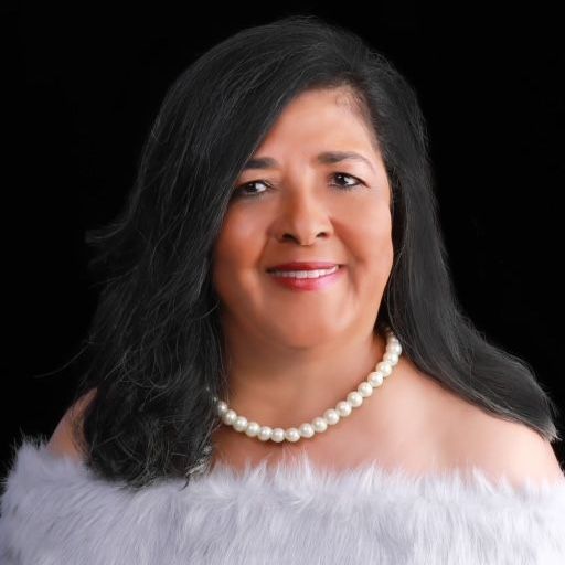 A woman is wearing a white fur coat and a pearl necklace.