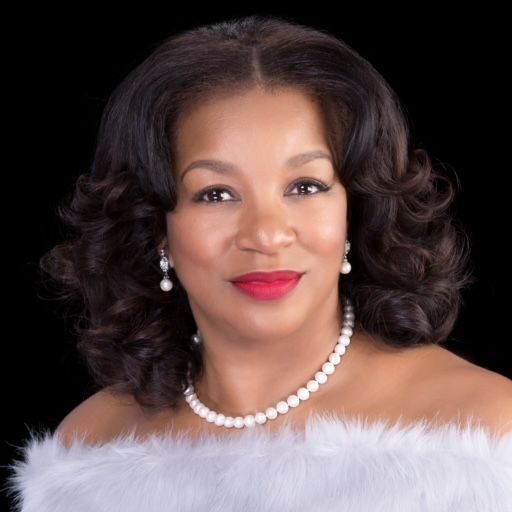 A woman wearing a white fur coat and a pearl necklace.