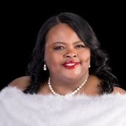 A woman is wearing a white fur coat and pearls.