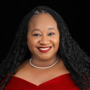 A woman wearing a red dress and a pearl necklace is smiling.