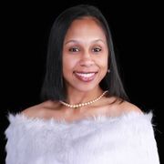 A woman wearing a white off the shoulder top and a pearl necklace