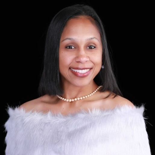 A woman wearing a white off the shoulder top and a pearl necklace