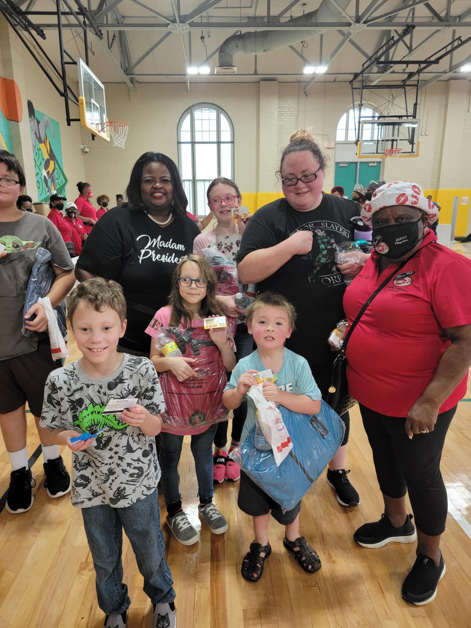 A group of people are posing for a picture in a gym.
