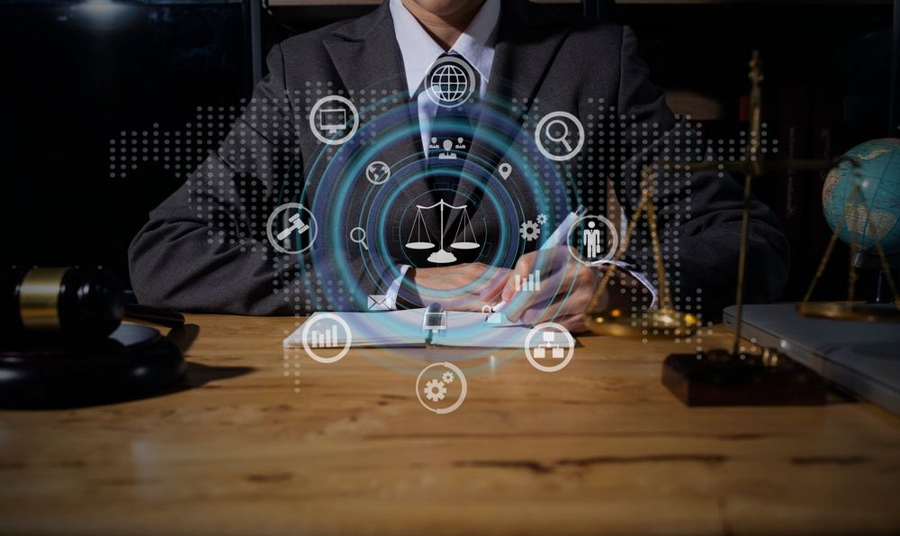 A person in a suit sits at a desk, with digital icons overlaying a law scale, globe, and gavel.