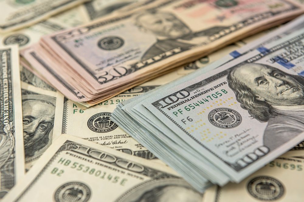 Stacks of US dollar bills: $100 and $50 notes.