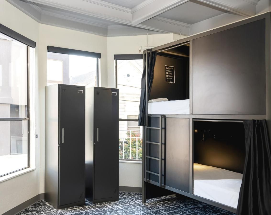 Bunk beds and lockers in a modern hostel room.