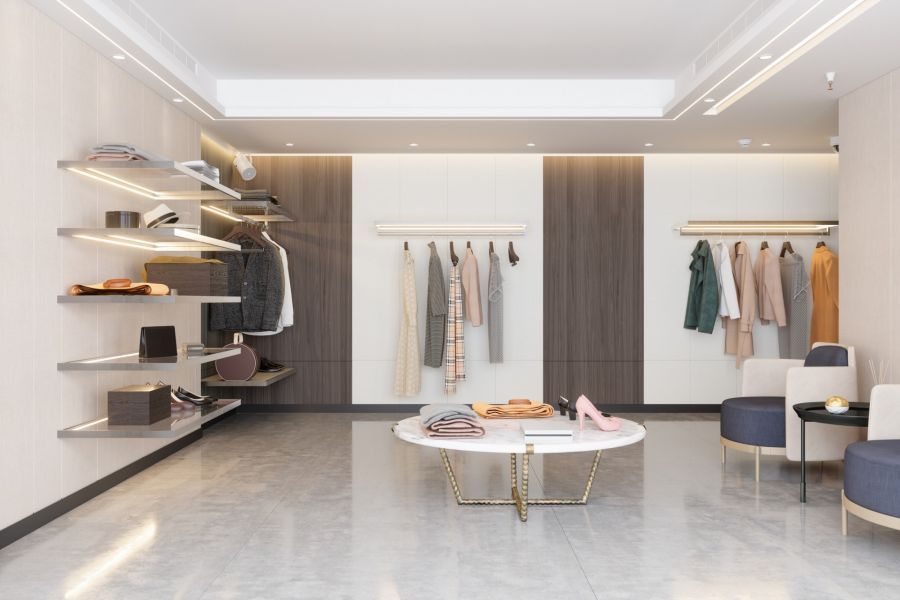 Minimalist clothing store interior with neutral racks, shelves, and round display tables