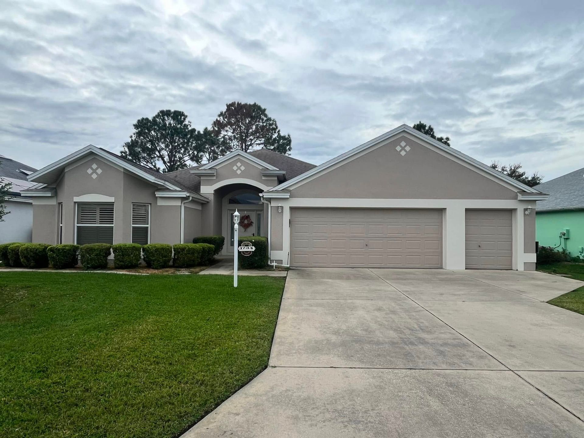 A house with two garage doors and a concrete driveway