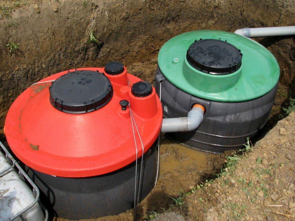 Two Septic Tanks Are Sitting in the Dirt Next to Each Other — Loogistics in Caloundra, QLD