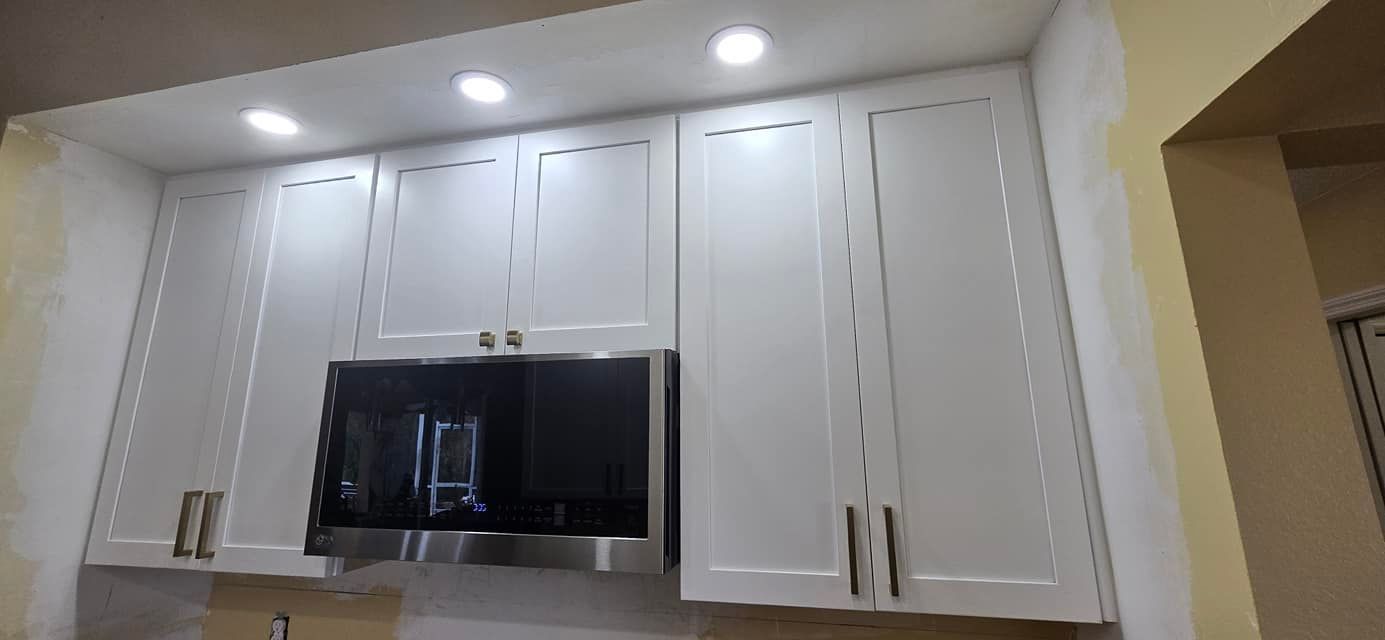A kitchen with white cabinets and stainless steel appliances.