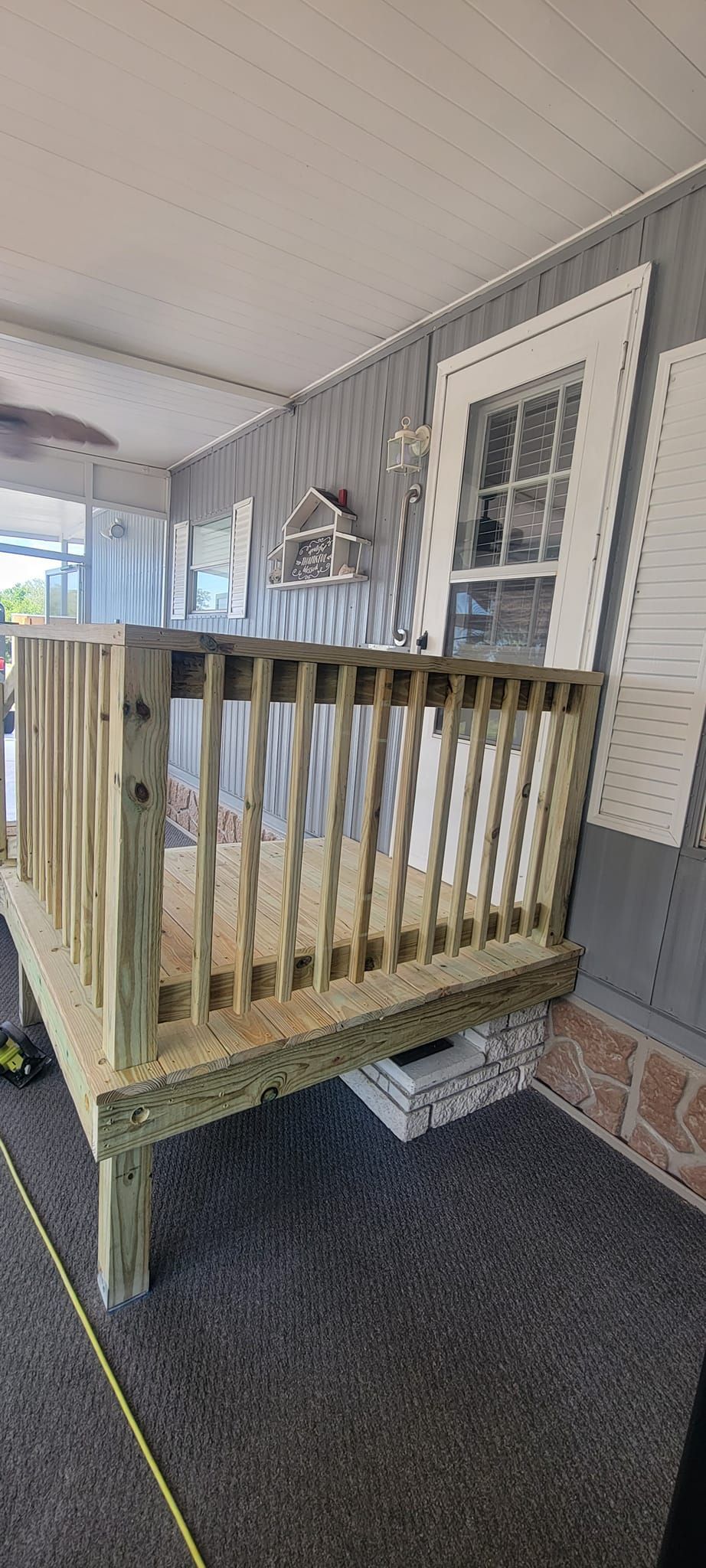 A wooden deck is being built in front of a mobile home.