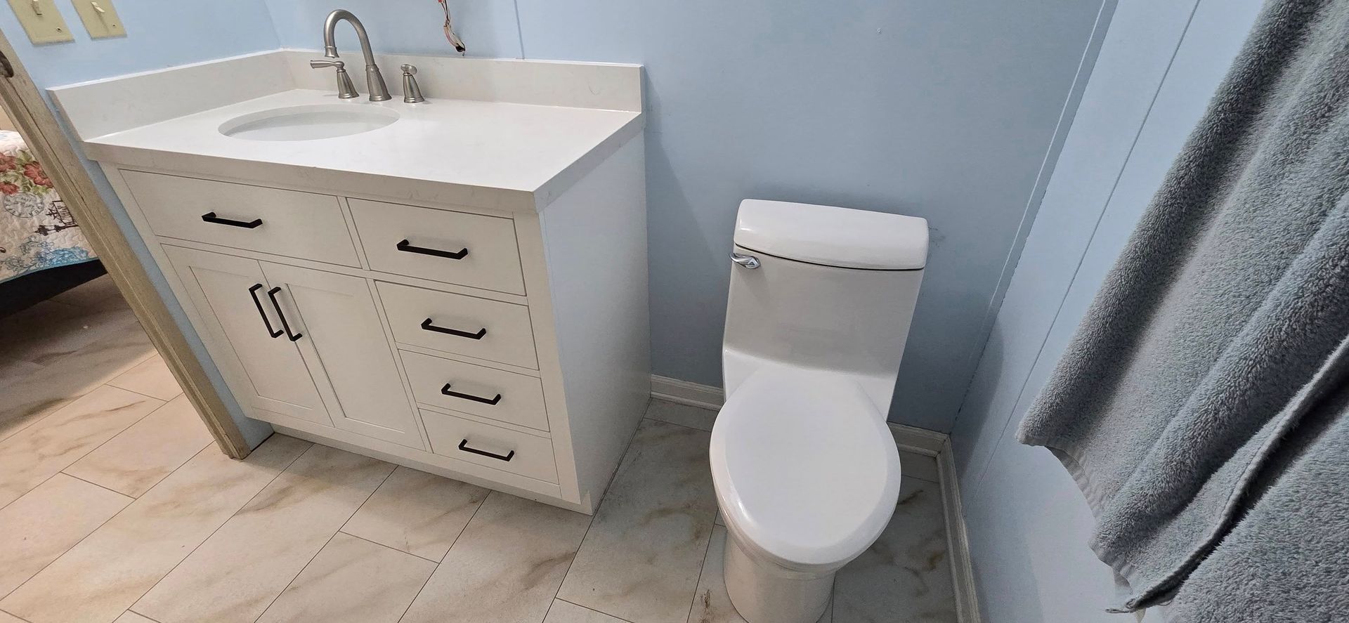 A bathroom with a toilet , sink and towel on the wall.