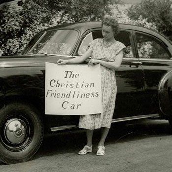 A monochrome image of a woman holding up a sign