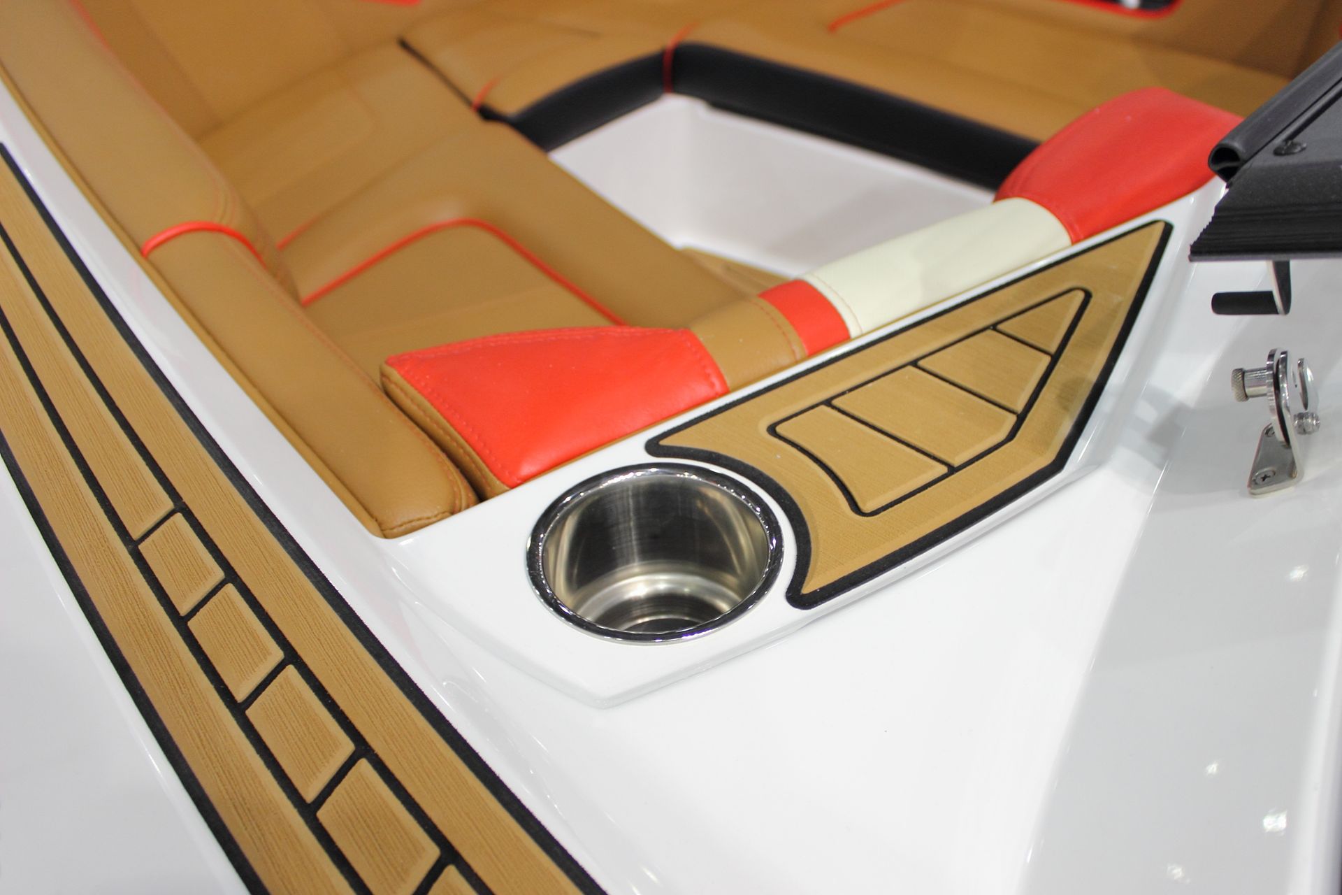 Intérieur du bateau avec sièges beiges et rouges, touches de blanc et porte-gobelet.
