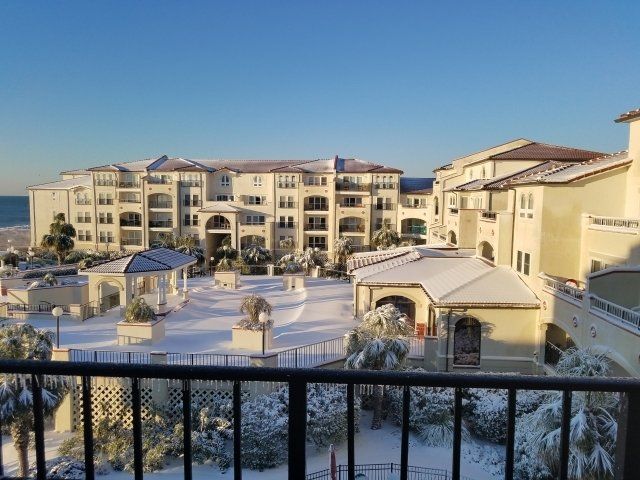 A balcony overlooking a large building covered in snow