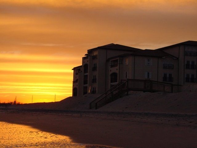 A sunset with a building in the foreground