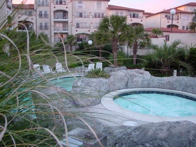 A swimming pool with a hot tub in front of a building
