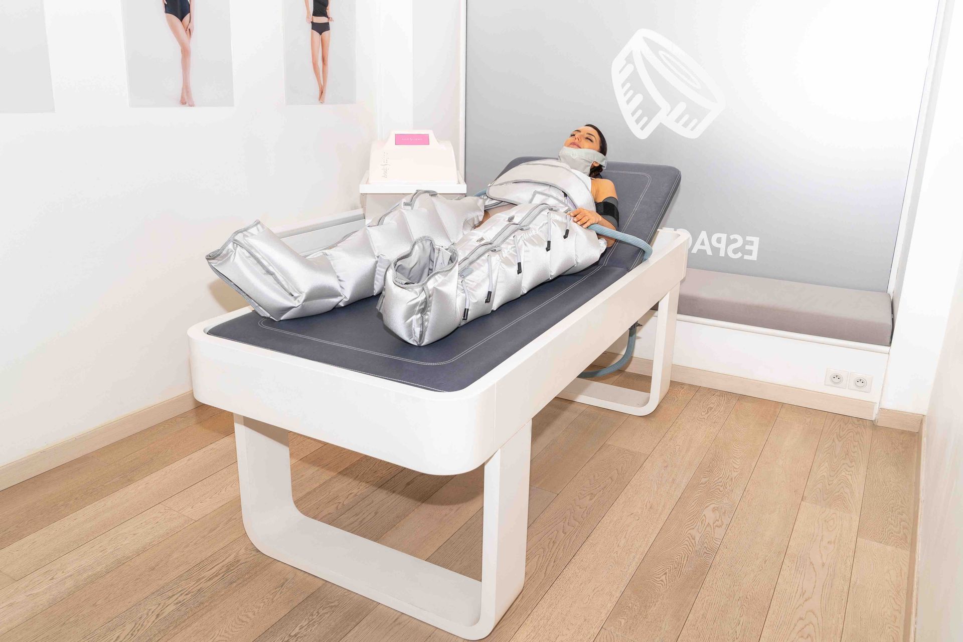Eine Person liegt in einem hellen Behandlungsraum auf einer Massageliege.