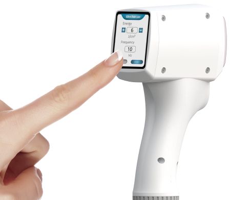 Eine Person drückt mit dem Finger einen Knopf an einer Maschine