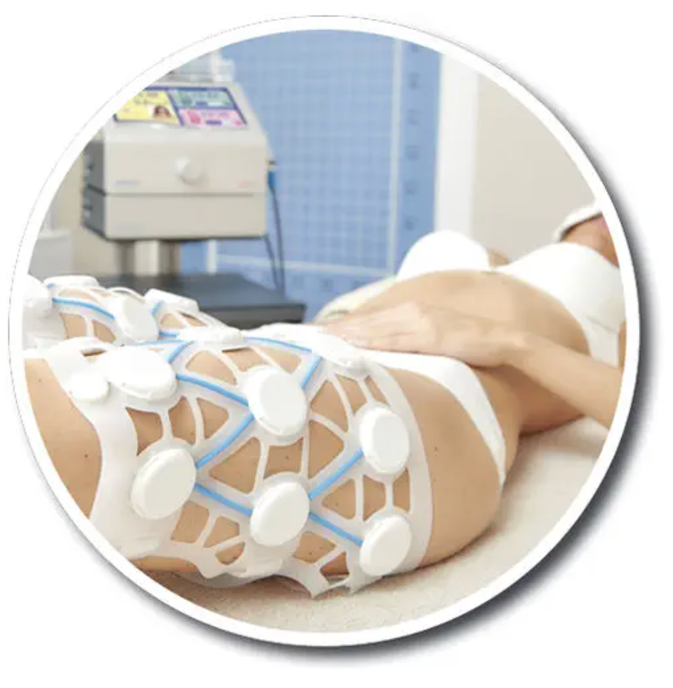 Eine Person, die sich in einer Klinik einer Körperbehandlung mit weißen Elektrodenpads am Bein unterzieht