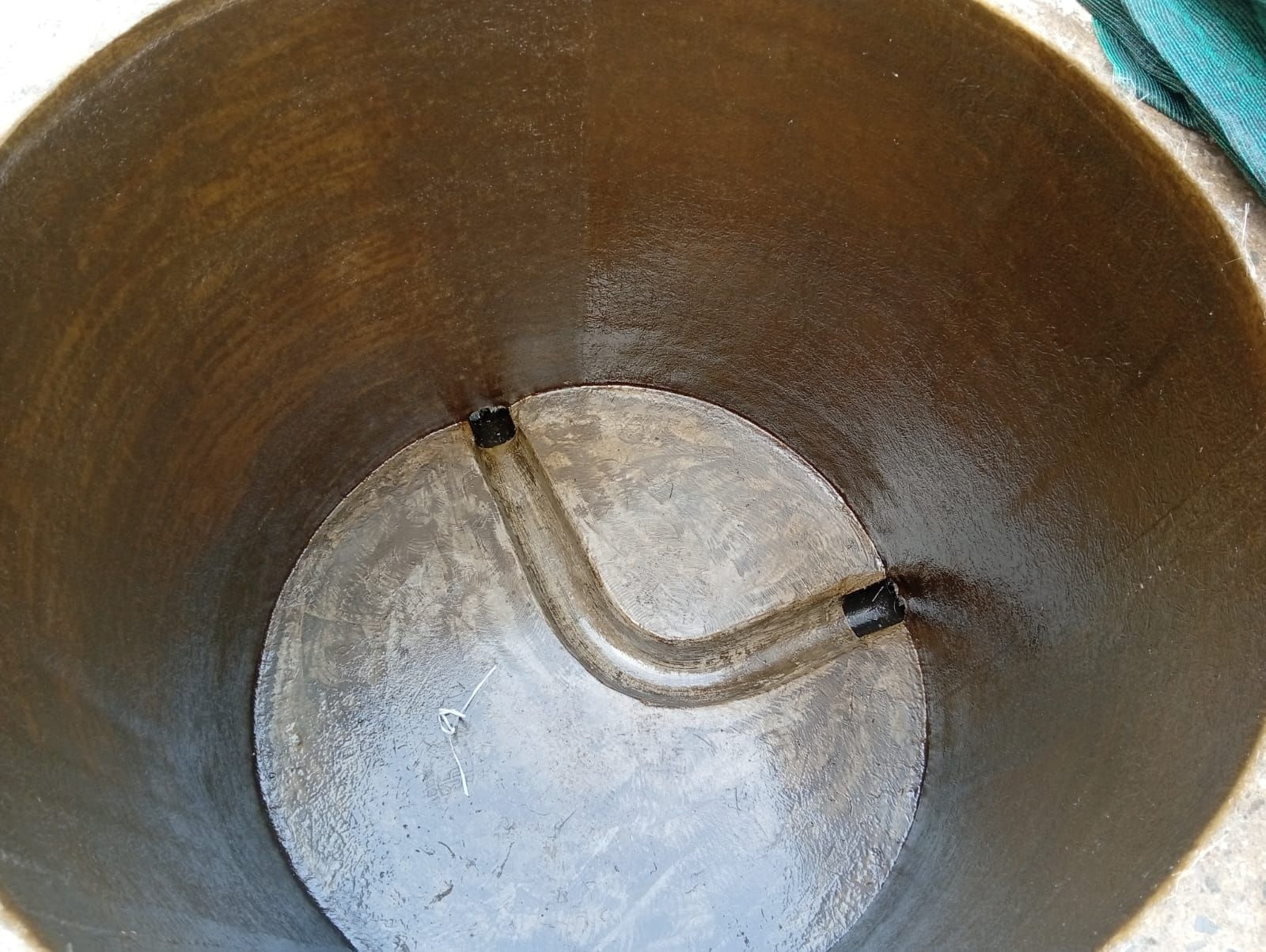 En el interior de un gran cilindro metálico, un tubo curvado conecta dos puntos de la pared interior.