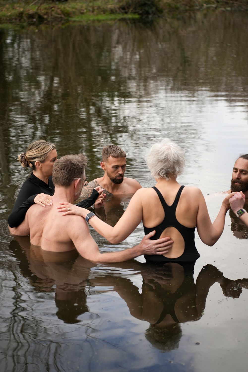 People standing in water holding hands