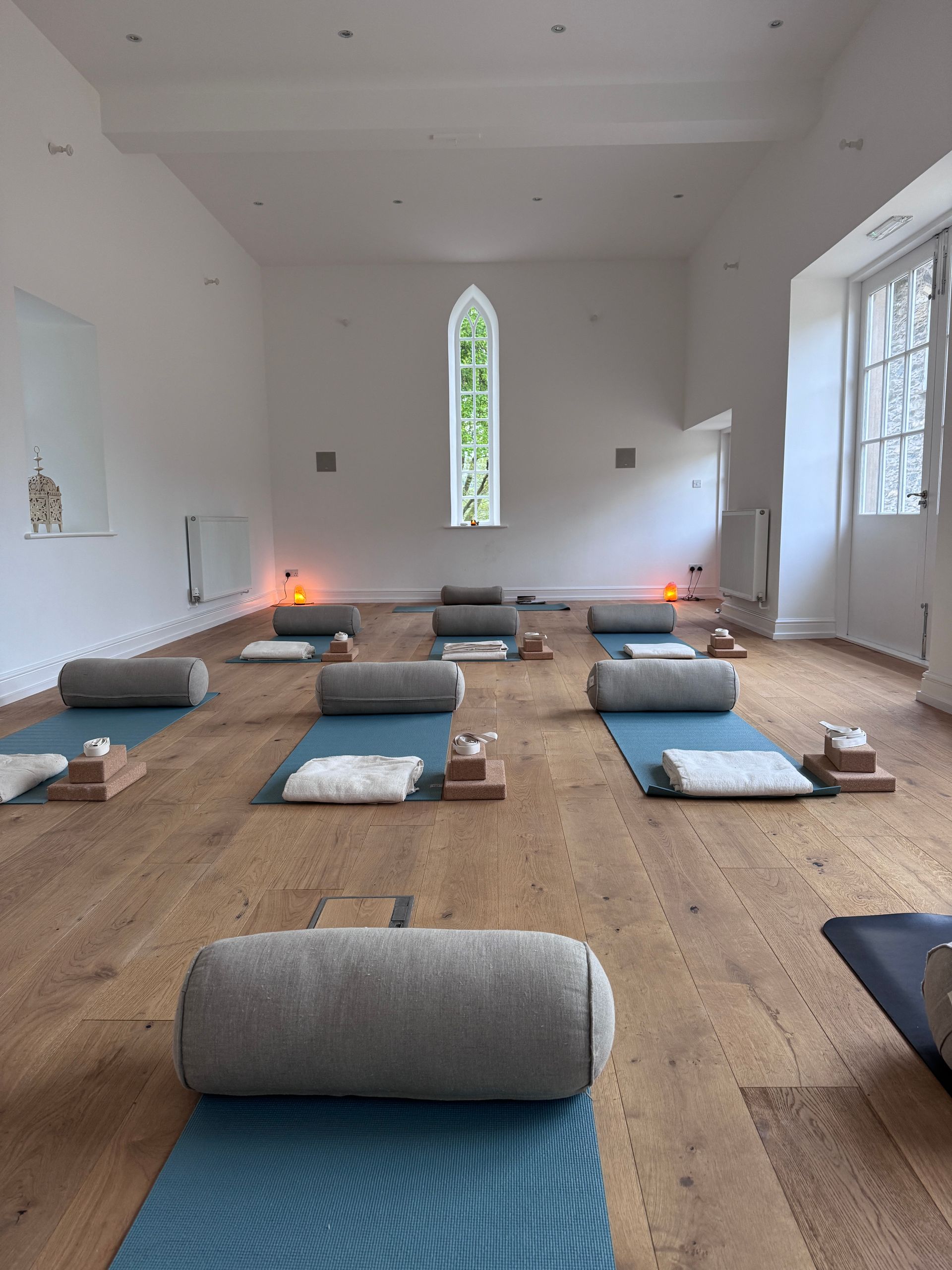 A yoga studio set up with blue mats and bolsters
